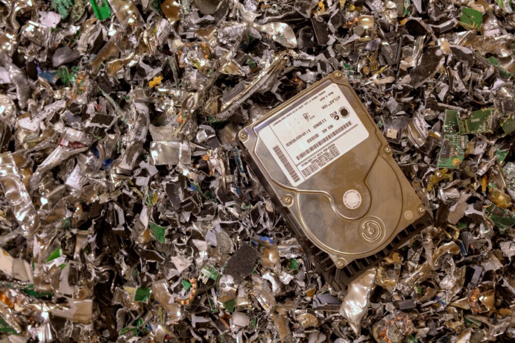 A hard drive in a pile of shredded metal